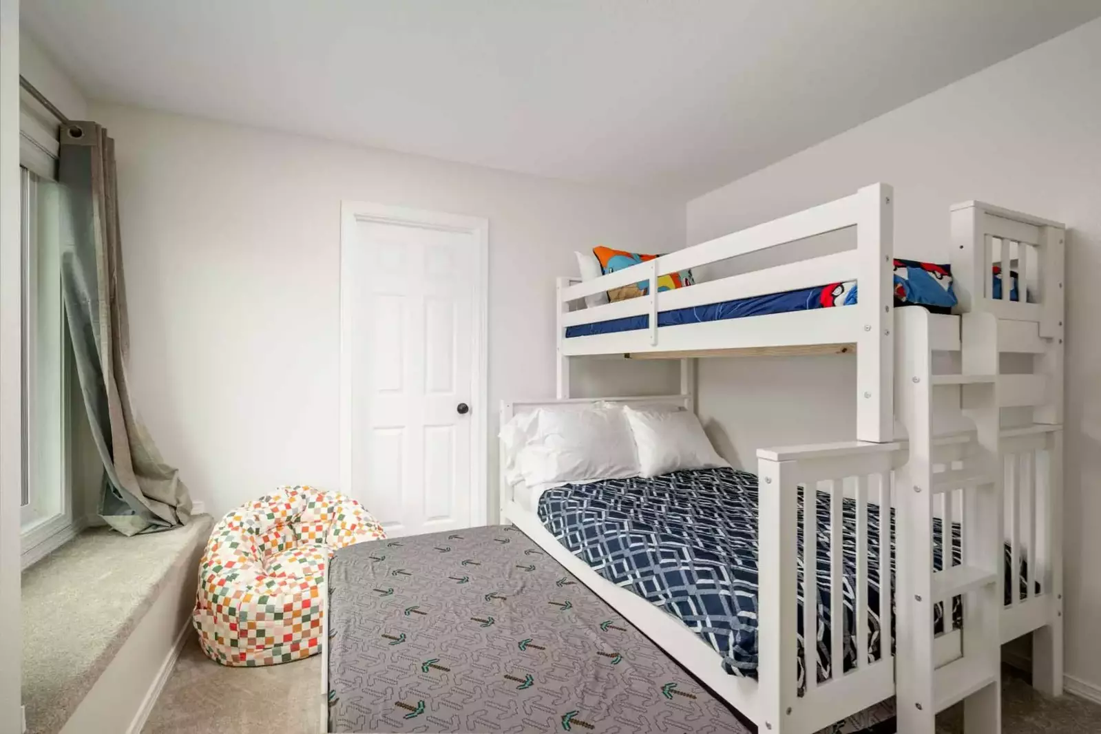 The third bed slides out from under the bottom bunk.