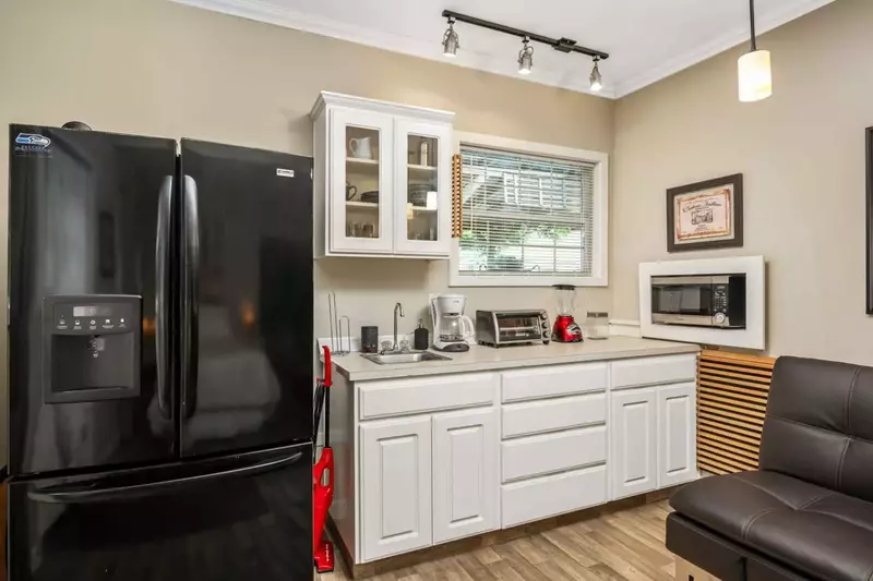 The kitchenette has a large fridge and many appliances.