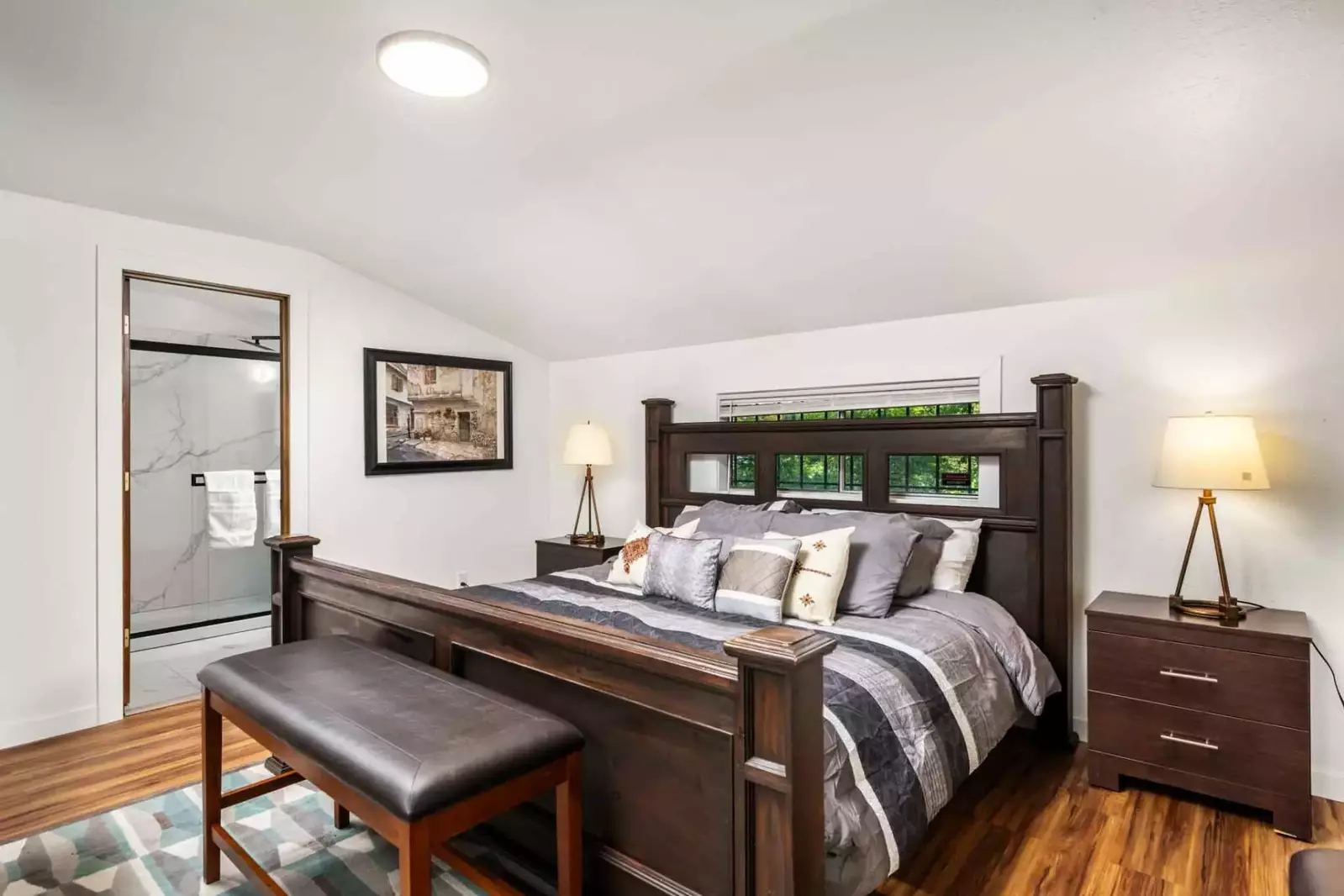 This bedroom features an en suite bathroom and luxurious king bed.