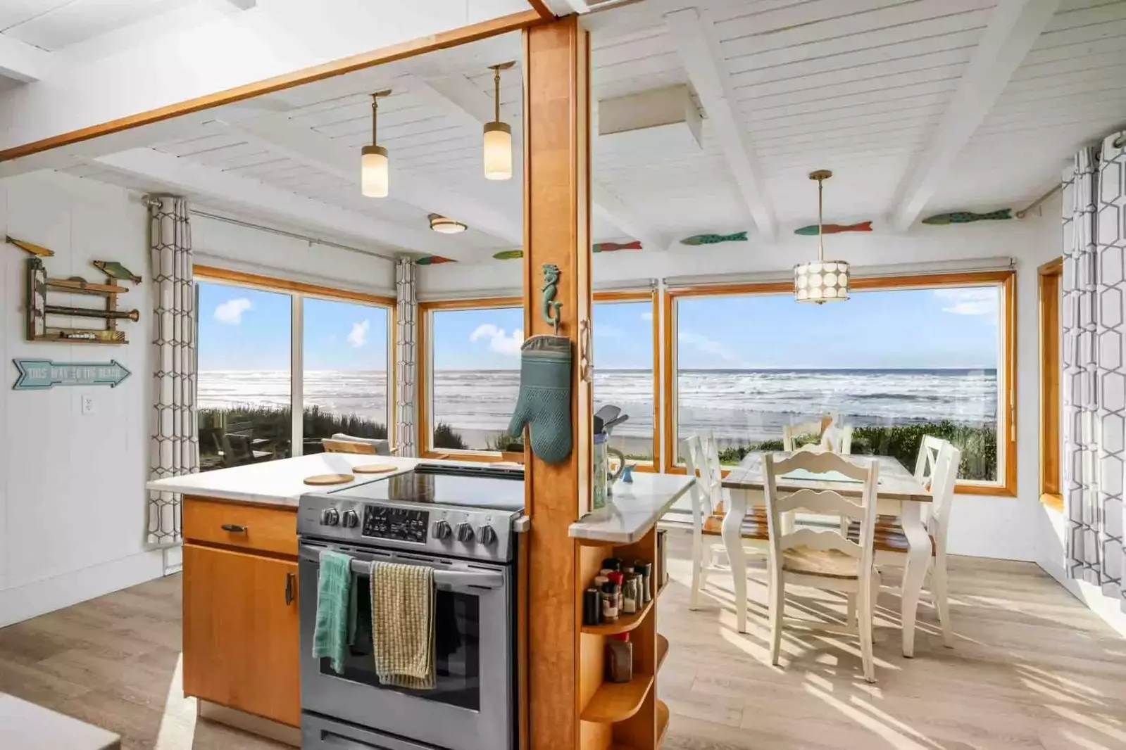 The adjacent dining/sitting room, complete with comfy seating, offers panoramic views of the coastline.