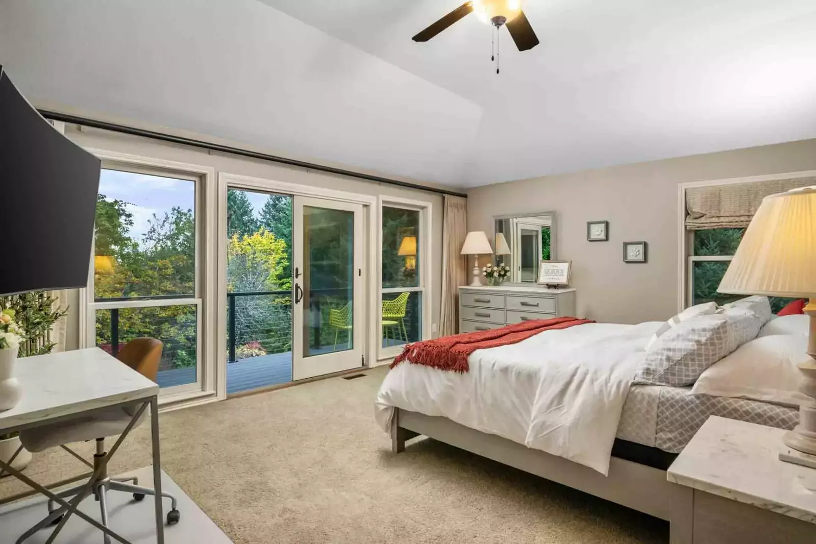 This bedroom has an excellent view of the lush trees outside.