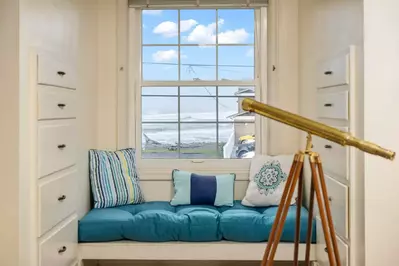 Cozy details like a window seat tucked into an upstairs dormer and TVs in the bedrooms add an extra touch of relaxation and charm.