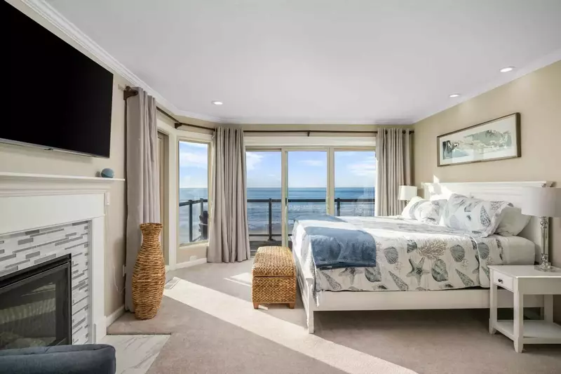 This bedroom is spacious with an incredibly comfortable bed, fireplace, smart tv, and ocean view.
