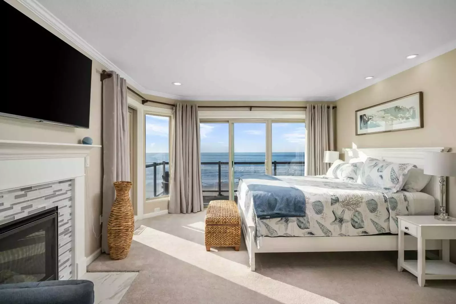 This bedroom is spacious with an incredibly comfortable bed, fireplace, smart tv, and ocean view.