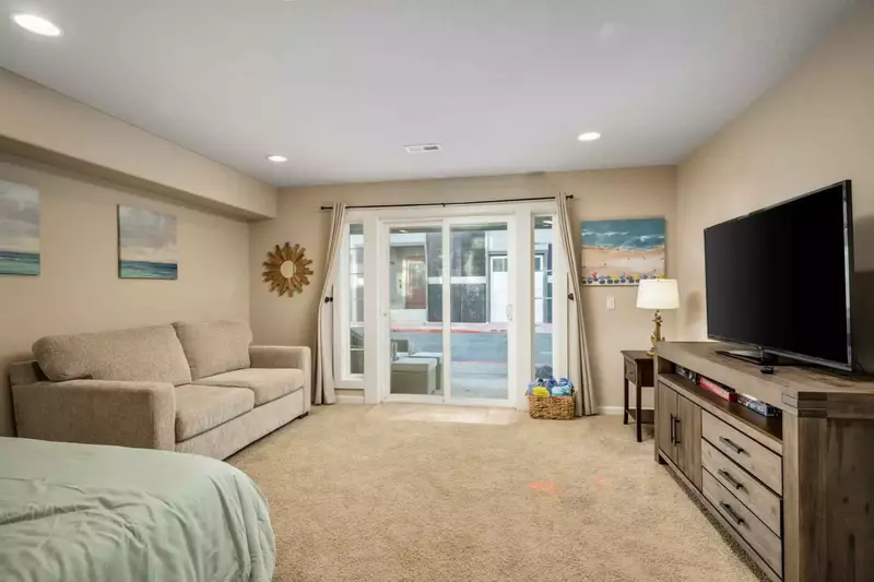 This room has a smart tv, comfy bed, and quick access to the outside.