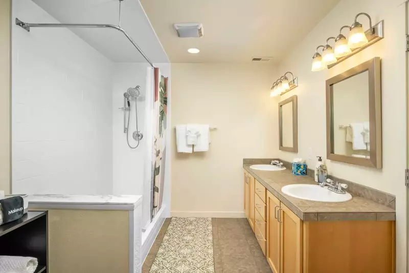 This bathroom has two sinks and a shower with excellent water pressure.