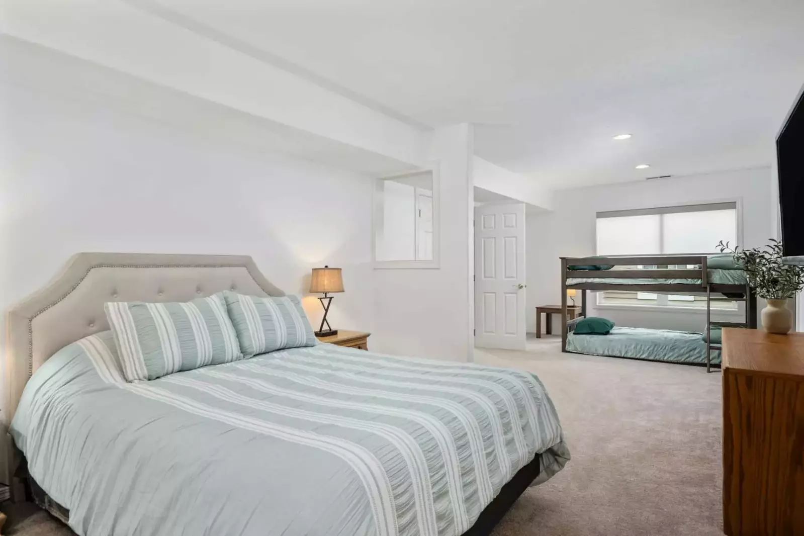 This bedroom has multiple beds and a smart tv.