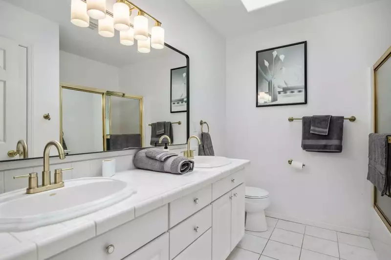 Another bathroom featuring two sinks and a shower with robust water pressure.