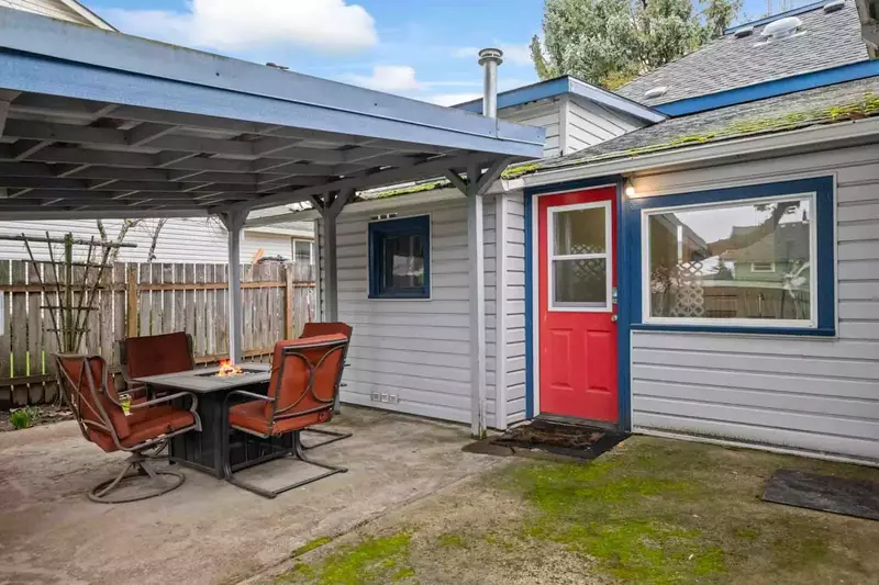 The primary entrance is through the red door on the patio.