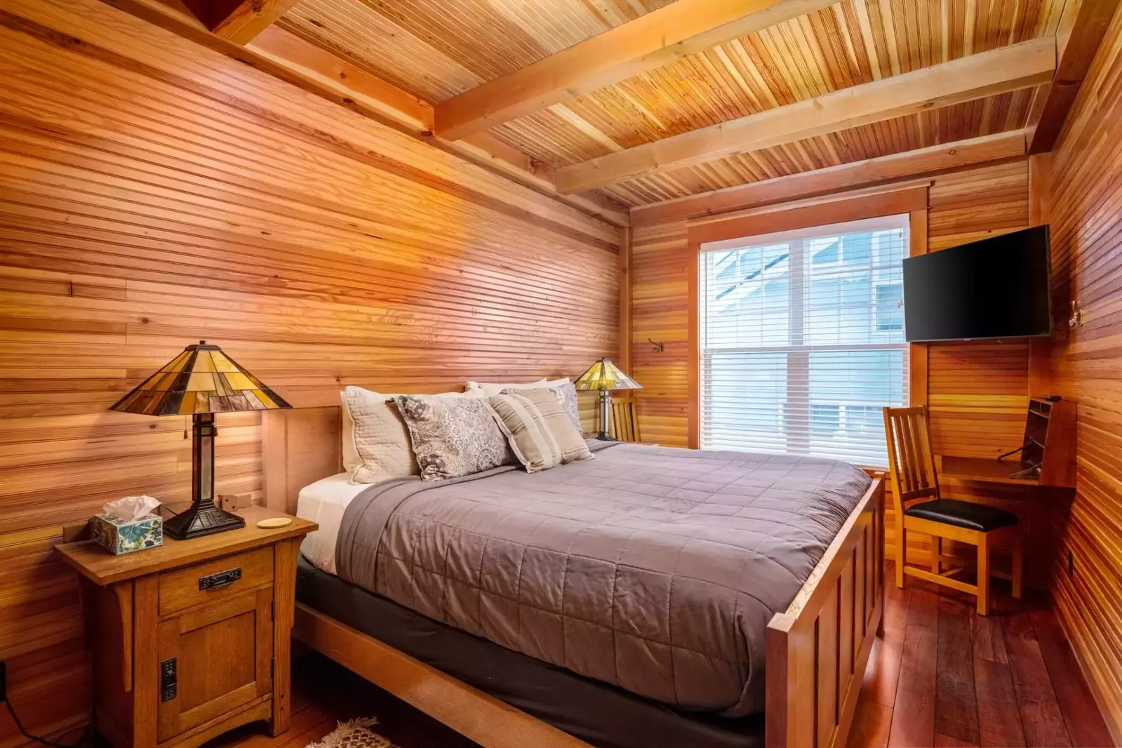 An accessible king bedroom on the main floor has a Smart TV, fold down desk area and a nearby bath.