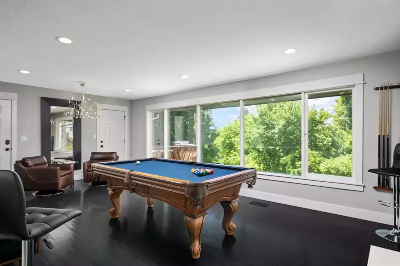 The pool table is an exquisite room with large windows.