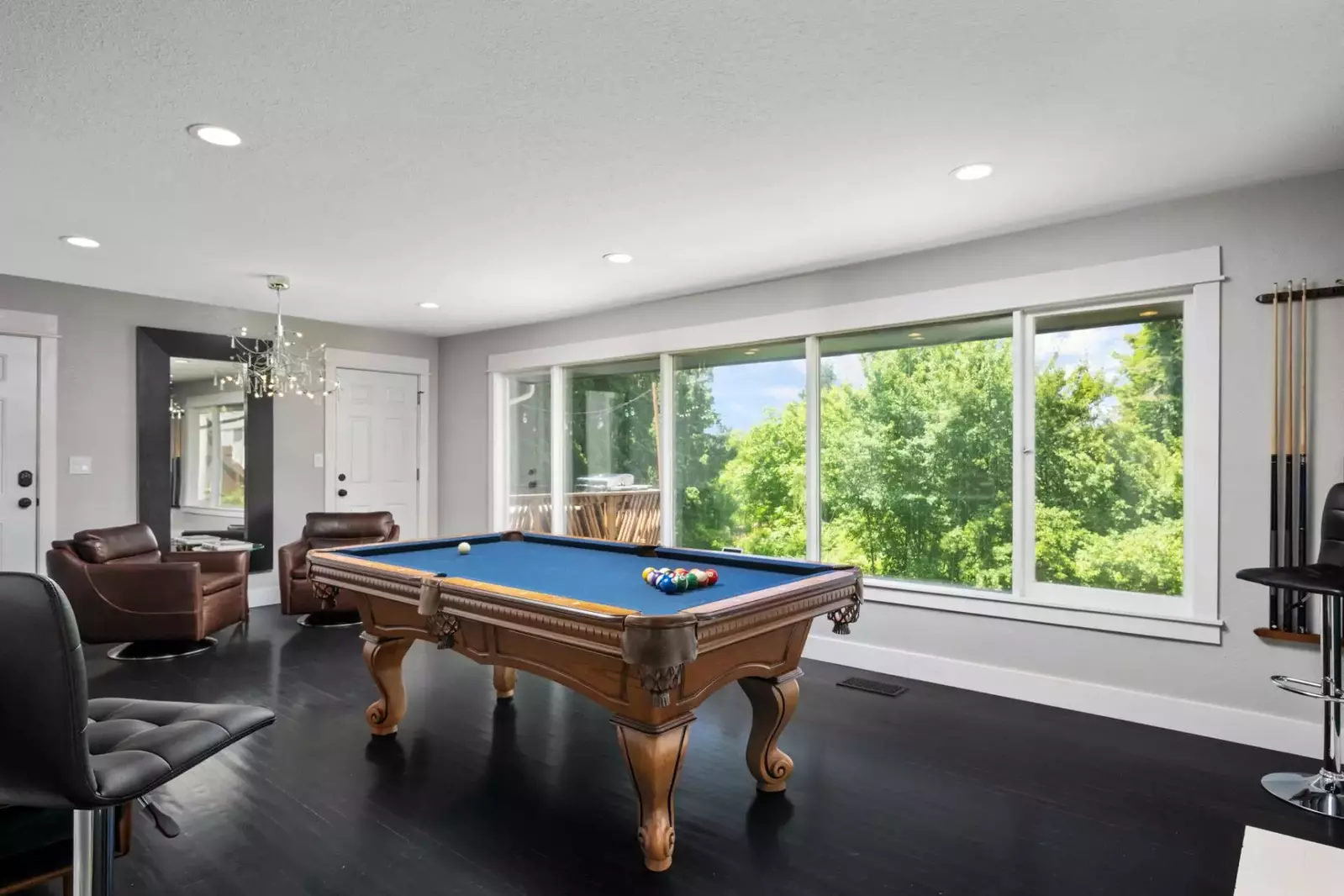 The pool table is an exquisite room with large windows.