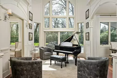 Enter into the gorgeous foyer with its grand piano being bathed in natural light from the enormous bank of windows.