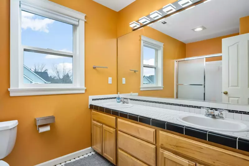 Another bathroom featuring two sinks and a shower with robust water pressure.
