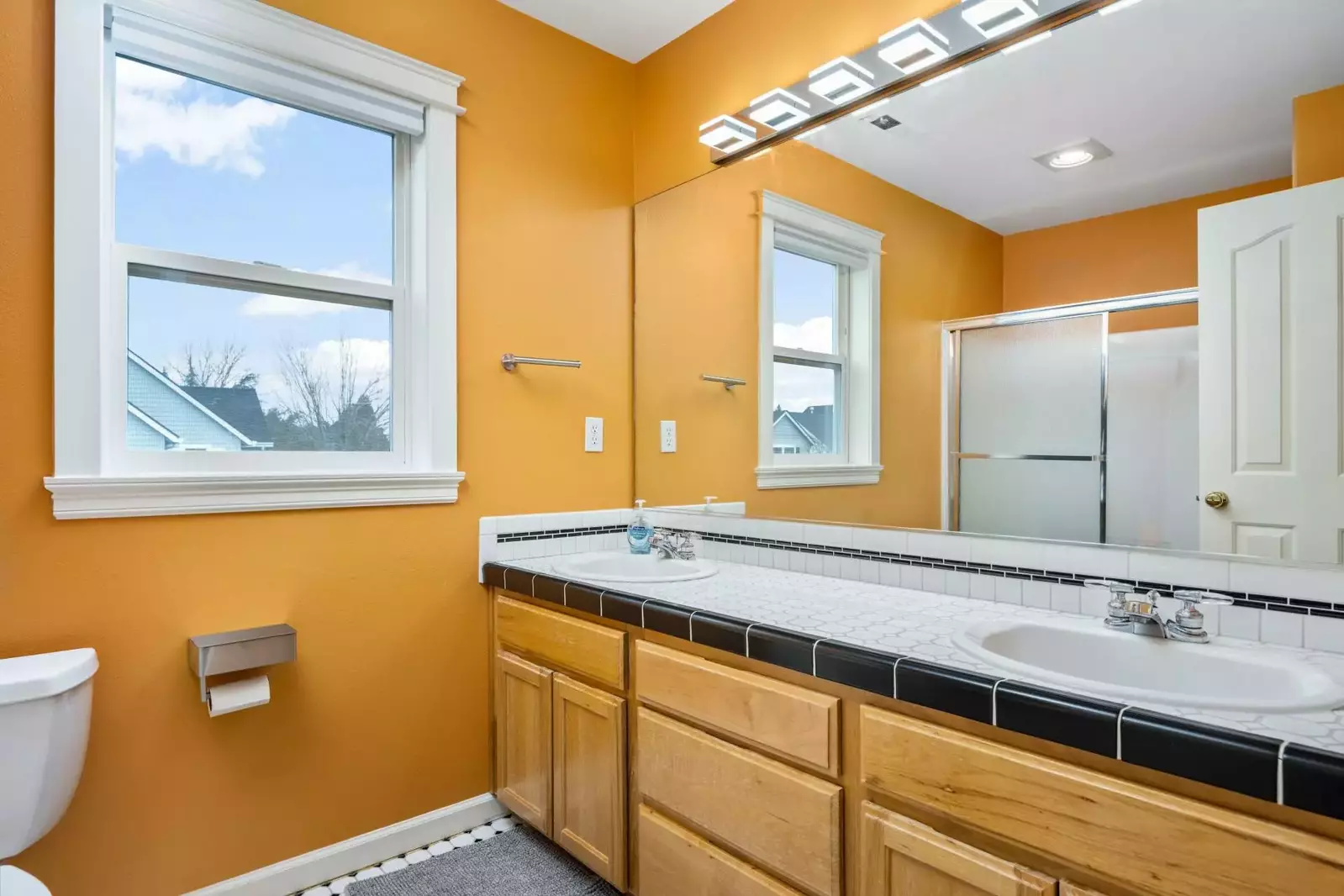 Another bathroom featuring two sinks and a shower with robust water pressure.