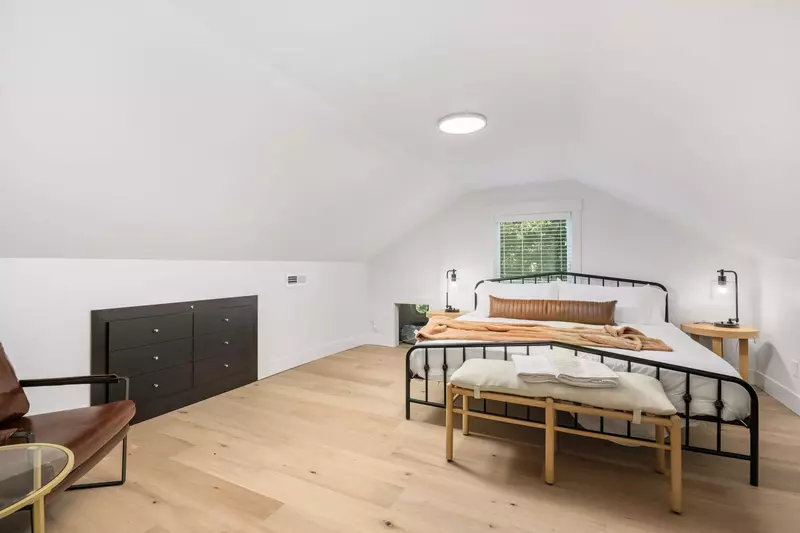 Primary suite that has a king bed, some additional seating, and even a place for your pup if you have one.