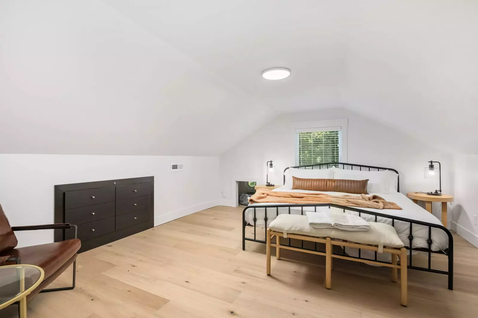 Primary suite that has a king bed, some additional seating, and even a place for your pup if you have one.