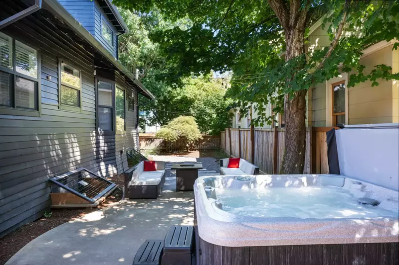 The fully fenced backyard is great for kids and pets and boasts ample seating, games, a fire-table, as well as a hot tub.