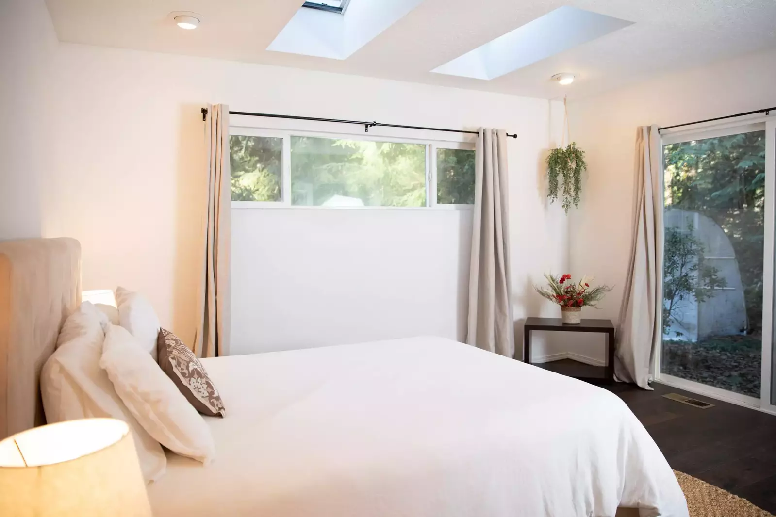 Guest cabin bedroom surrounded by trees and bathed in natural light.