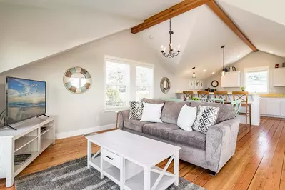 Warm wood floors with comfy seating for a night of streaming and cable access.