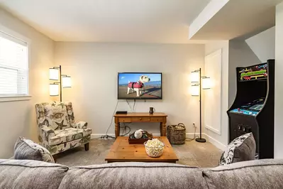 Descending downstairs you will find a wonderfully appointed bonus room with a shuffleboard table, arcade game, and flat-screen TV.