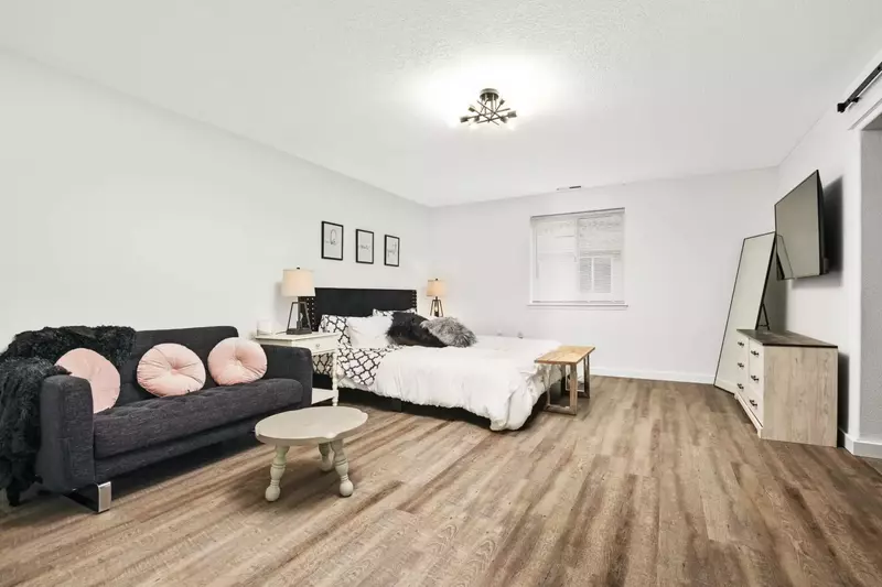 A spacious room with a comfy couch and a smart TV.