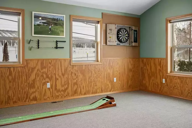 A mini putting green and a dart board are additional fun parts of the game room.