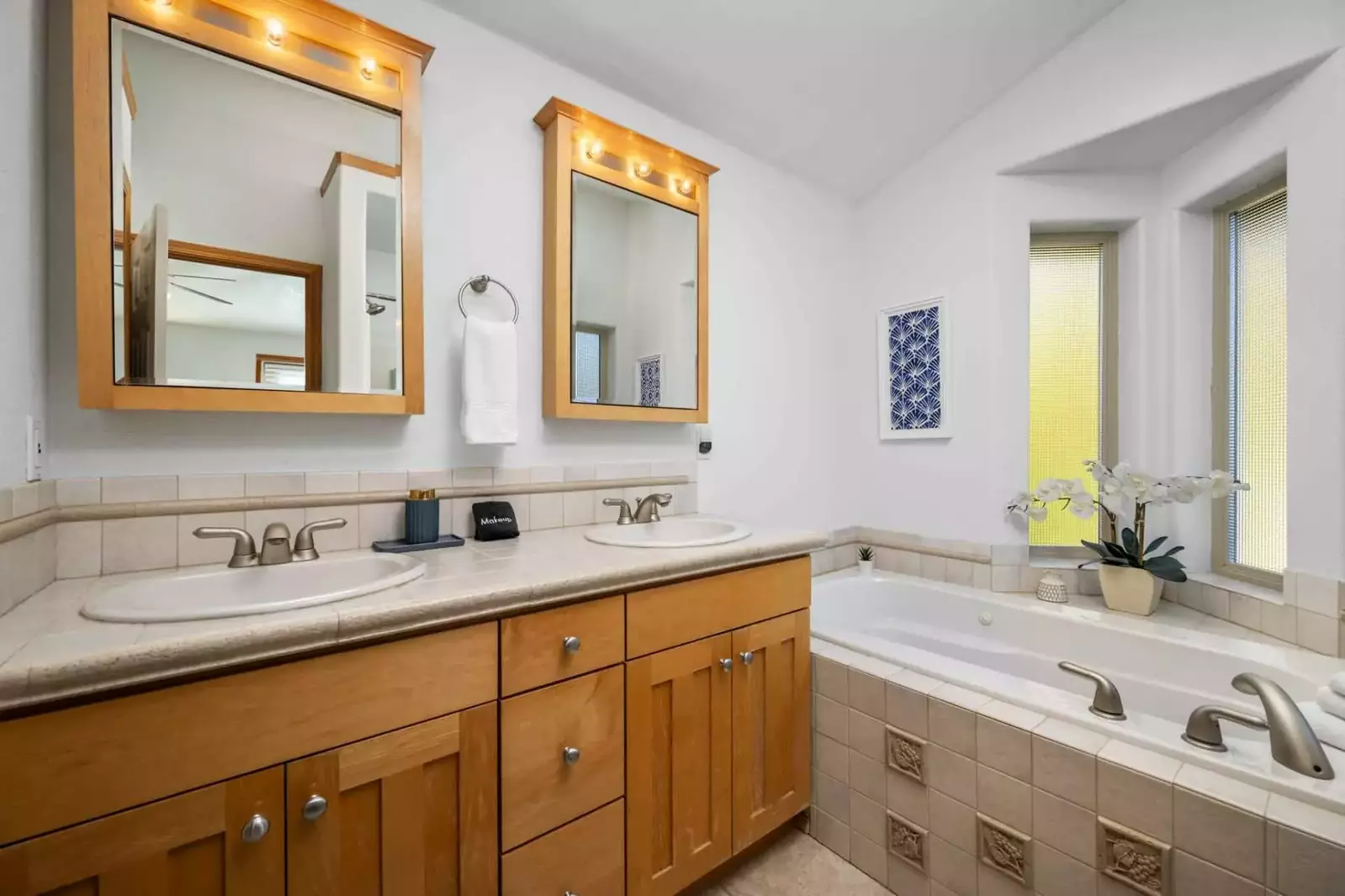 This bathroom has two sinks and a relaxing tub.