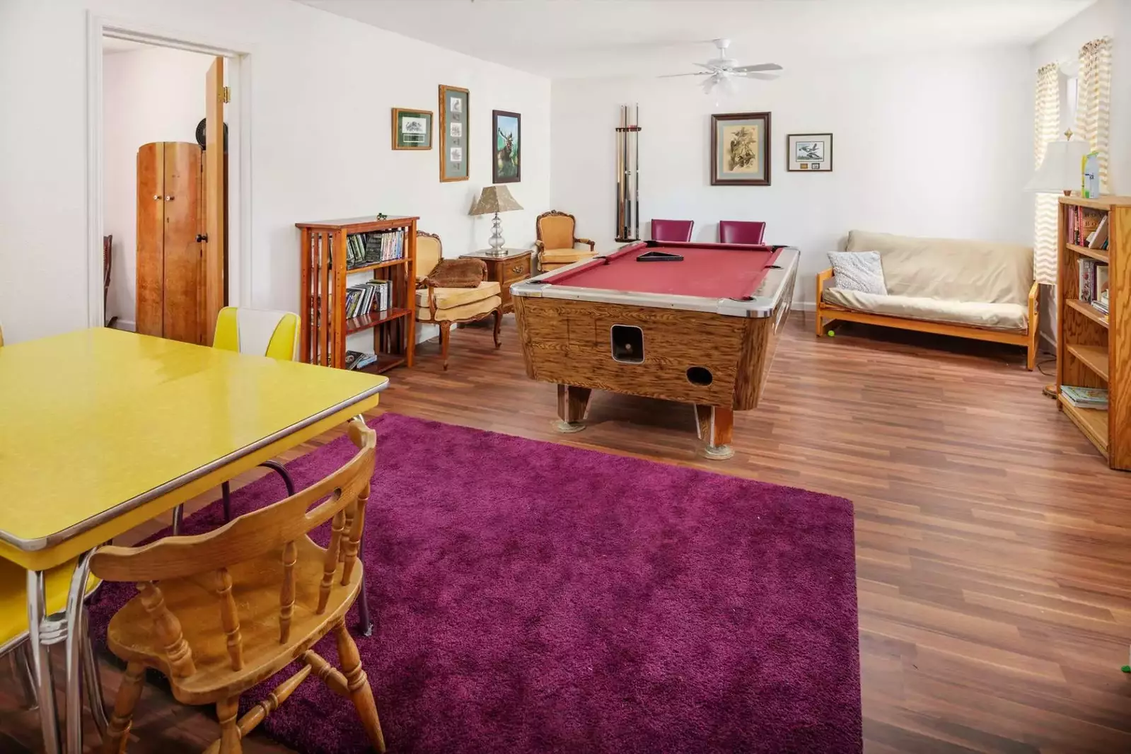 Bottom level entertainment room with pool table, futon, and games.