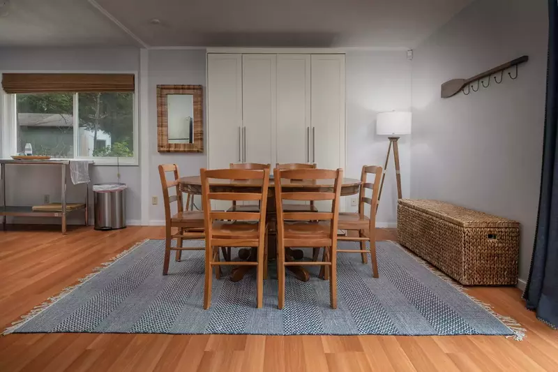 Dining area with Murphy bed on the far wall with bedding located in storage on the left