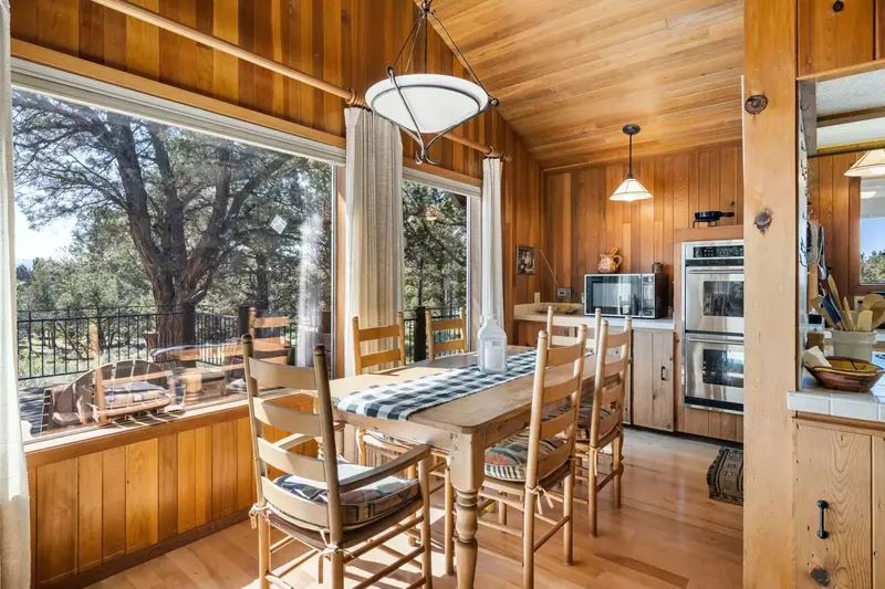 The dining table is right by the large windows.