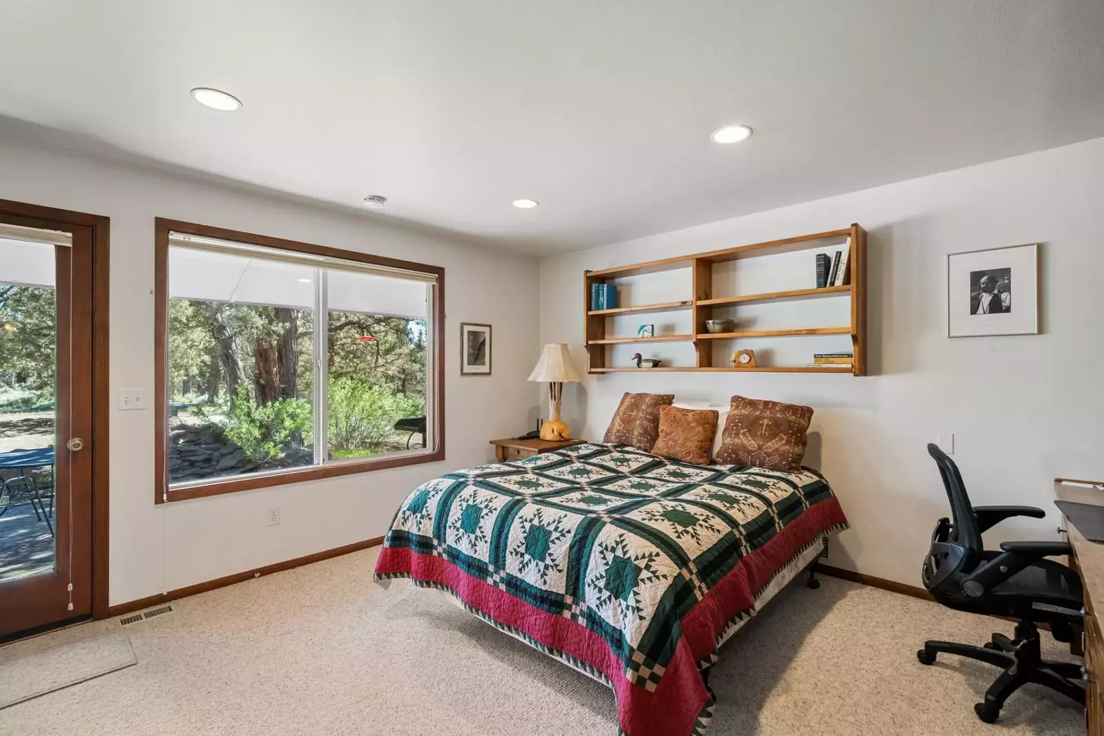 This bedroom has a home office set up and immediate access to nature.