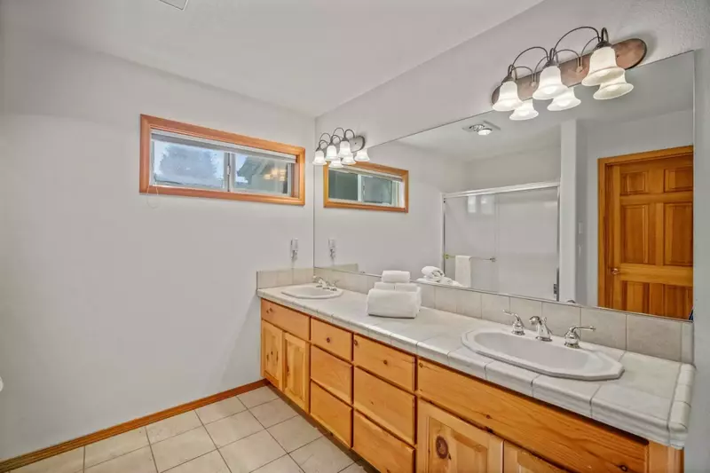 Primary suite bathroom offers dual sinks.