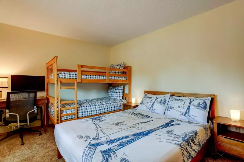 Third bedroom features a Queen and Twin bunks.  Functional workspace and professional chair.