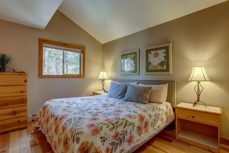Guest bedroom on lower level - King bed, 5-drawer dresser, end tables with reading lamps, and mirror.