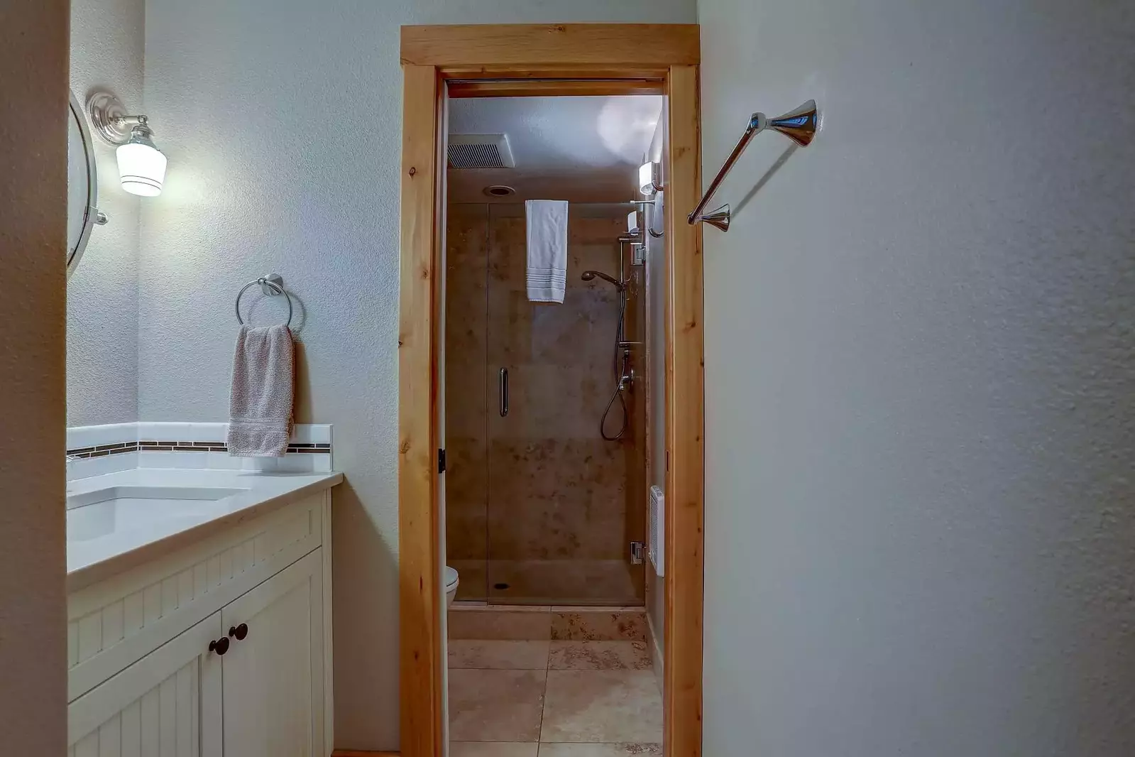 1st floor bathroom features extra large dual-headed shower and Travertine tile.
