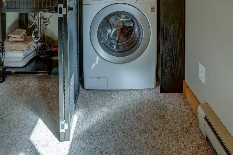 Stacked washer and dryer behind closed doors, in master suite.