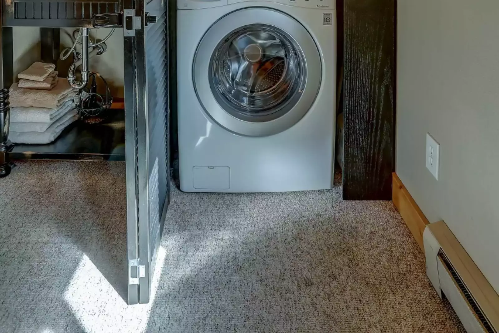 Stacked washer and dryer behind closed doors, in master suite.
