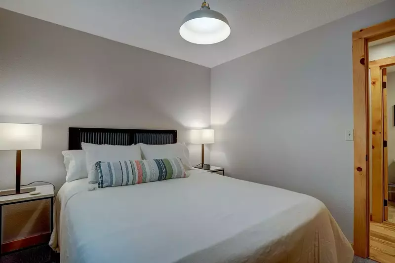 Queen bed in BR 3 with large window, end tables, reading lamps.