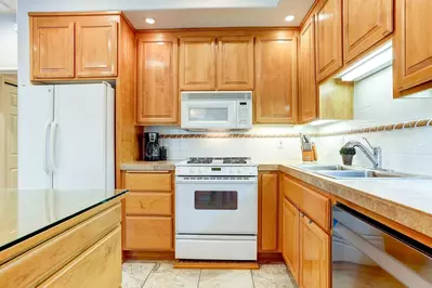 kitchen features tiled countertops and full array of appliances