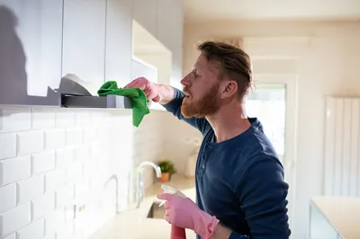man deep cleaning kitchen