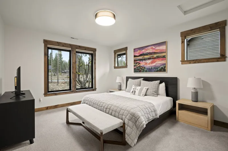 This bedroom has a comfy bed, smart, tv, and a nice view.