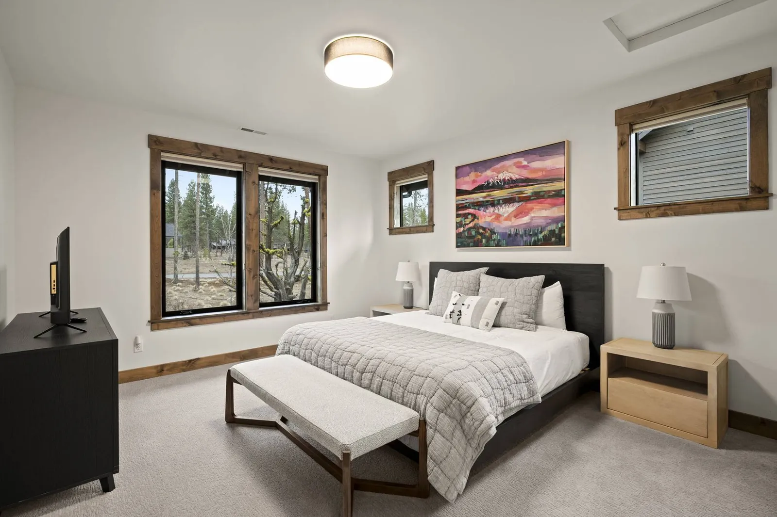 This bedroom has a comfy bed, smart, tv, and a nice view.