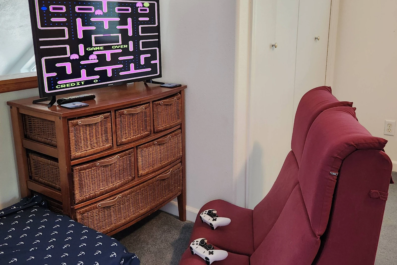 Cozy upstairs game nook with retro arcade fun and comfortable seating for relaxing after a beach day.
