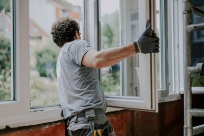 repairman fixing window at house